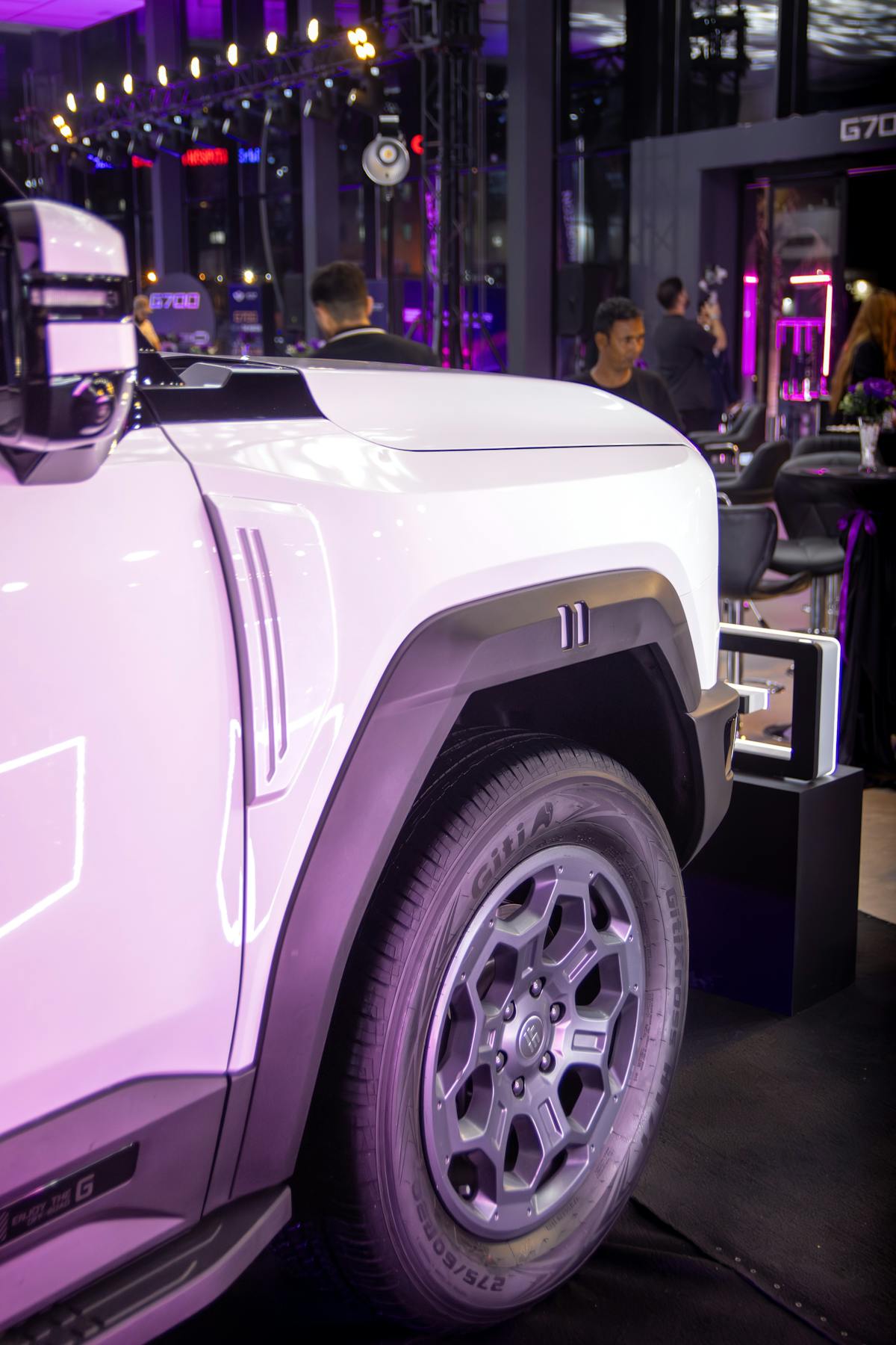Modern SUV wheel and side profile in a showroom